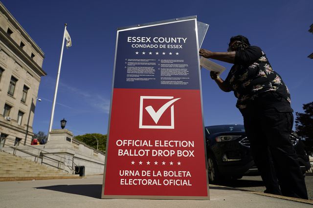 Woman deposits her ballot in an election drop box in Newark, N.J